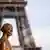 Estátua de máscara em frente à Torre Eiffel, em Paris