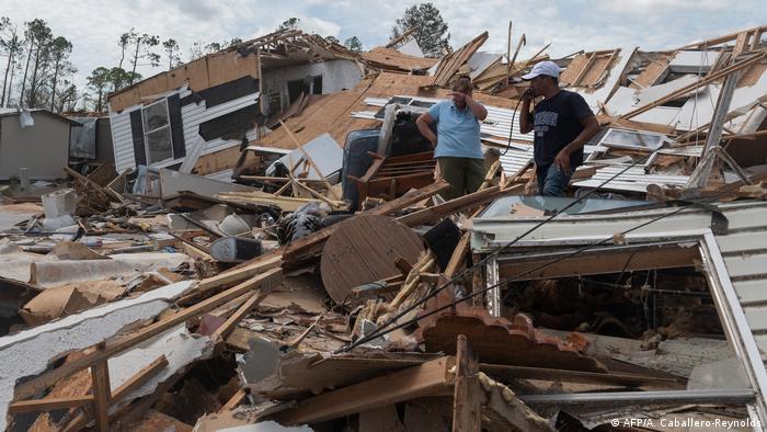 A couple react as they go through their destroyed mobile home following the passing of hurricane Laura in Lake Charles, Louisiana, on August 27, 2020
