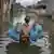 A man wades through a flooded street in Karachi after heavy monsoon rains