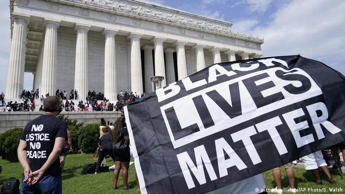 Demonstrators in front of the Lincoln Memorial holding a BLM banner