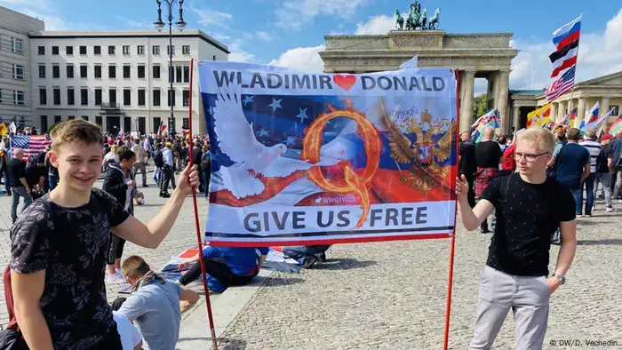 Berlin protesters holding banner asking for Donald Trump and Vladimir Putin to free Germany (DW/D. Vachedin)