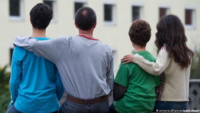 A family in front of an asylum reception center outside of Berlin