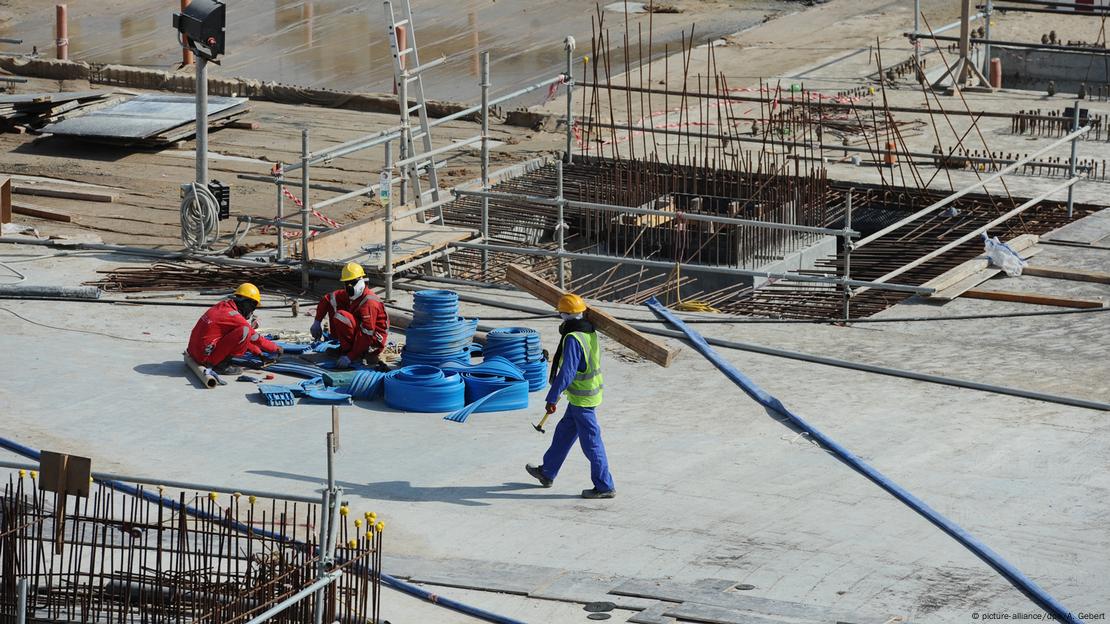 Foto mostra três trabalhadores da construção civil em uma obra