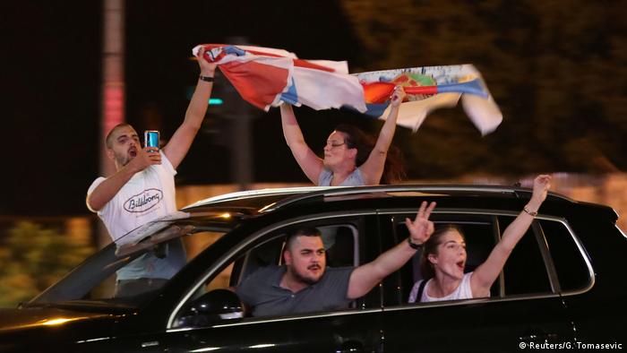 Opposition supporters gesturing triumphantly from a car in Podgorica, Montenegro