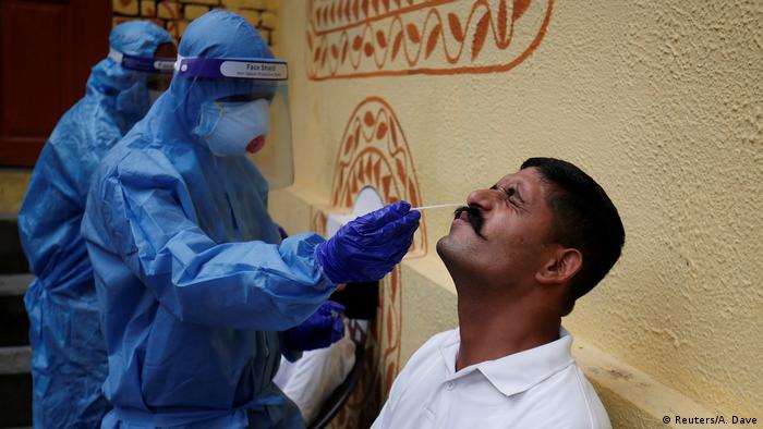 A health care worker takes a swab from a police officer