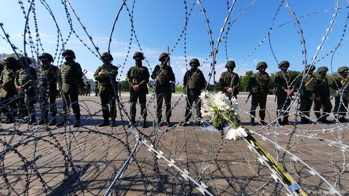 Soldiers hide behind barbed wire