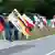 Manifestantes seguram bandeiras do Império Alemão em beira de estrada