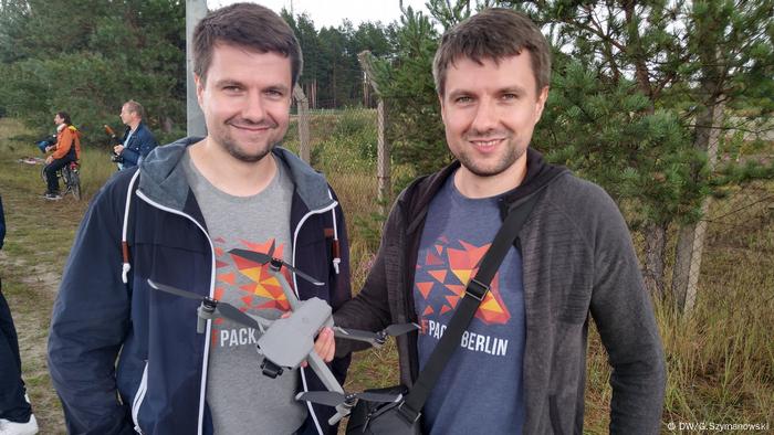 Robert and Andreas Wolf holding a drone in their hands with which they make aerial photos of the Gigafactory