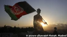 FILE - In this Aug. 19, 2019, file photo, a man waves an Afghan flag during Independence Day celebrations in Kabul, Afghanistan. Officials on both sides of Afghanistan's protracted conflict say efforts are ramping up for the start of intra-Afghan negotiations, a critical next step to a U.S. negotiated peace deal with the Taliban. (AP Photo/Rafiq Maqbool, File) |