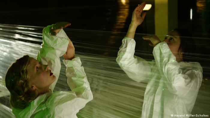 Escena de la obra de danza-teatro el eXXperimento. Escenario dividido en partes iguales por capas de plástico transparente.
