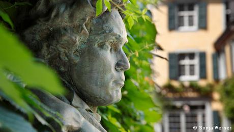 Beethovenkopf zwischen den Blättern einer Hecke 