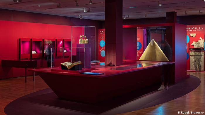 view from the exhibition 'The Emperors and their pillars of power': a red hall with a crown and various exhibits