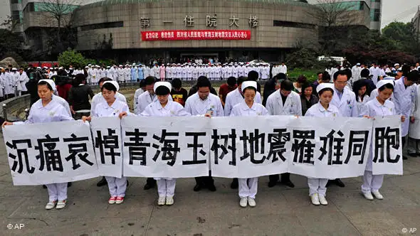 Medical staff hold up a sign which reads "Deep sorrow in commemoration of Qinghai Yushu earthquake victims" at a hospital in Chengdu in southwest China's Sichuan province Wednesday, April 21, 2010.