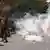 Мігранти тікають після того, як поліція застосувала проти них сльозогінний газ
