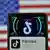 Логотип TikTok на экране смартфона и флаг США