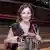 Sarah Willis sitzt mit einem Horn in einem leeren Konzertsaal