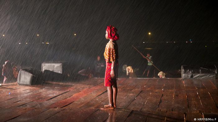 Human Rights Film Festival 2020: image from the film Mrs. F.. A black woman stands on a stage at night in the pouring rain (HRFFB/Mrs F)