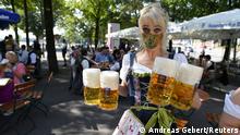 A server carries mugs during a barrel tapping at a beer garden near Theresienwiese where Oktoberfest would have started today as COVID-19 continues in Munich, Germany, September 19, 2020. REUTERS/Andreas Gebert TPX IMAGES OF THE DAY