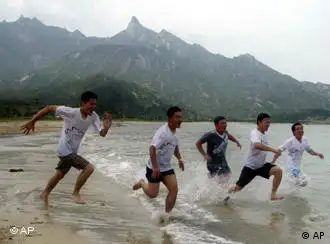 South Korean tourists play on Kumgangsan Beach in Kosung of Diamond Mountain, North Korea, Saturday, July 3, 2004. The beach opened in 2002 is part of an inter-Korean cooperative project of two Koreas. (AP Photo/Lee Jin-man, Pool)