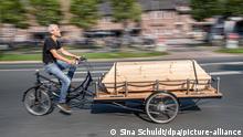16.09.2020, Niedersachsen, Oldenburg: Michael Olsen fährt mit seinem Bestattungsfahrrad durch die Stadt. Wenn ein Mensch stirbt, wird er mit einem Leichenwagen zum Bestattungsinstitut oder zum Friedhof gefahren. Ein Oldenburger Künstler hat ein Sargfahrrad gebaut. Er will so den Tod in den Alltag zurückbringen. Die Reaktionen sind kontrovers. Foto: Sina Schuldt/dpa | Verwendung weltweit