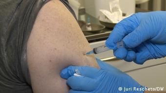 Врач делает прививку в руку вакциной Спутник V