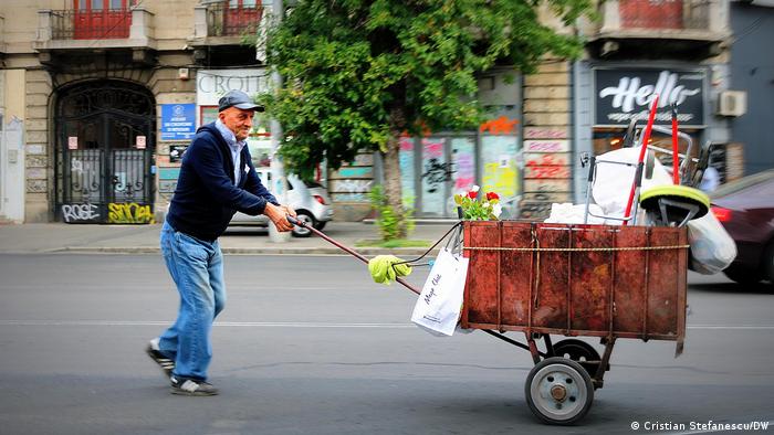 Ein alter Mann schiebt einen Handkarren durch die Straßen von Bukarest