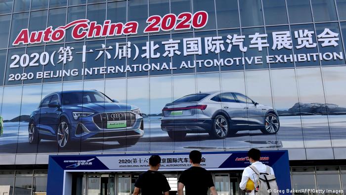 Workers walk into an exhibition hall during preparations ahead of the Beijing Auto Show in Beijing on September 24,