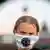 Greta Thunberg, de cabelo preso e usando máscara de proteção com o logo "Fridays for Future". 