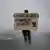 Homem segura cartaz que diz: "y va a caer! Yja va a caer! La constitución de Pinochet", ao lado de uma foto de Pinochet com um x vermelho no rosto. 