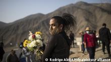 25.09.2020, Peru, Lima: Shaina hält auf dem Friedhof «Martires 19 de Julio» Blumen während der Beerdigung von Paula Sebastian, die mit einer Covid-19-Erkrankung im Alter von 62 Jahren gestorben ist. Foto: Rodrigo Abd/AP/dpa +++ dpa-Bildfunk +++ |