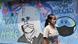 A woman in a facemask walks past a coronavirus-themed mural in Tangerang, Indonesia A woman in a facemask walks past a coronavirus-themed mural in Tangerang, Indonesia