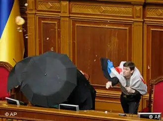 Un parlamentario oficialista lanza huevos de regreso envuelto en una bandera rusa.