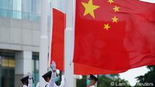 Members of the Hong Kong Police Honour Guard raise flags during a flag-raising ceremony marking China's National Day at Golden Bauhinia Square in Hong Kong, China October 1, 2020. REUTERS/Lam Yik
