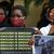 Nigerian women in red face masks hold up posters decrying gender-based violence