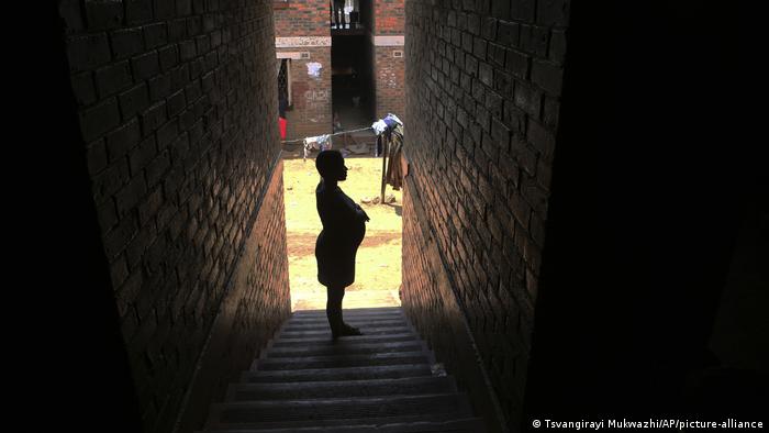 Zimbabwe | Schwangere Frau in Seitenstraße