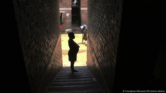 A pregnant woman waits in a passageway for her turn to deliver her baby, in Harare, Zimbabwe