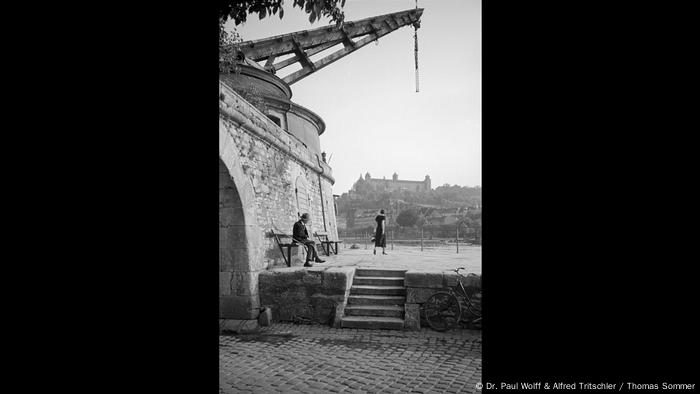 Ein Mann beobachtet eine Frau am Mainufer in Würzburg (Dr. Paul Wolff & Alfred Tritschler / Thomas Sommer)