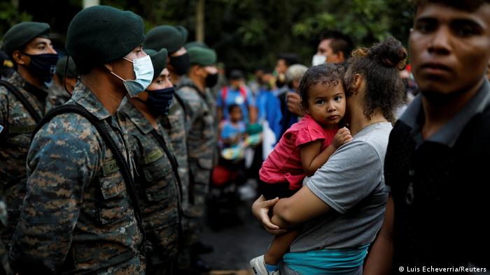 Foto de caravana de migrantes de Honduras frente a soldados de Guatemala