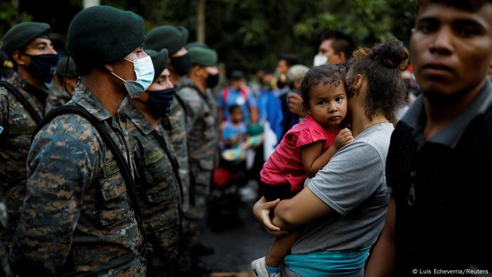 Foto de migrantes de Honduras frente a soldados de Guatemala