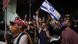 An Israeli protester waves a national flag An Israeli protester waves a national flag