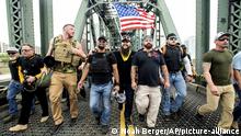 Members of the Proud Boys and other right-wing demonstrators march across the Hawthorne Bridge during an End Domestic Terrorism rally in Portland, Ore., on Saturday, Aug. 17, 2019. The group includes organizer Joe Biggs, center in green hat, and Proud Boys Chairman Enrique Tarrio, holding megaphone. (AP Photo/Noah Berger) |