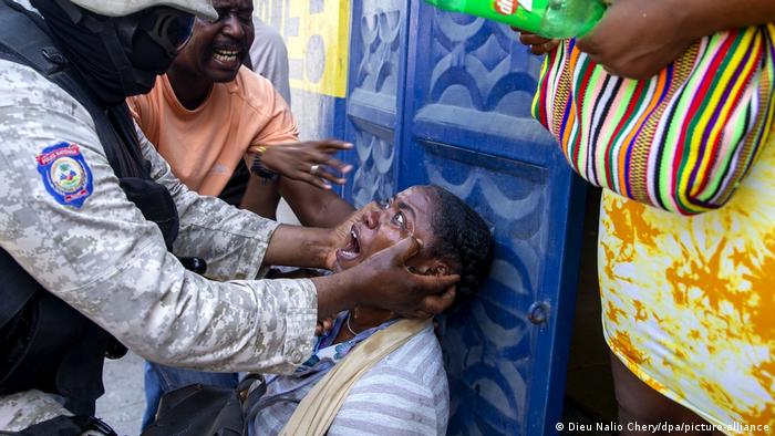 Mujer haitiana, atendida tras ser alcanzada por gases lacrimógenos en una manifestación.