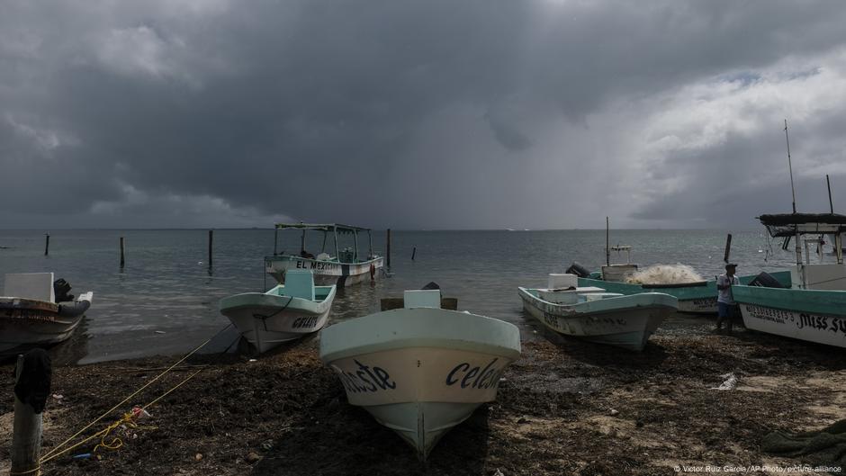 En el horizonte, el huracán Delta llega a la parte trasera de los barcos de pesca en la playa