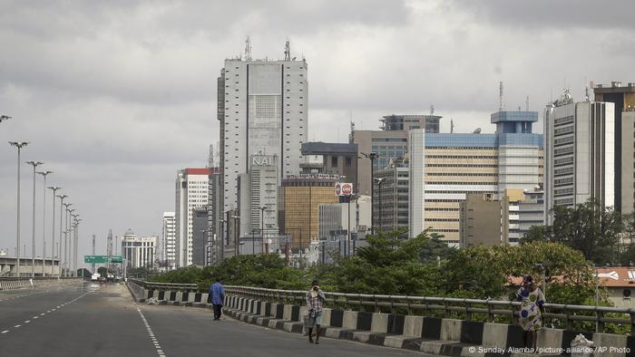 A handful of pedestrians walk along a deserted highway in Lagos, Nigeria