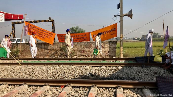 Farmers in Punjab walk next to train tracks