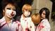 Young Japanese women wearing face masks, heavy dark eye makeup and white shirts splashed with fake blood Young Japanese women wearing face masks, heavy dark eye makeup and white shirts splashed with fake blood