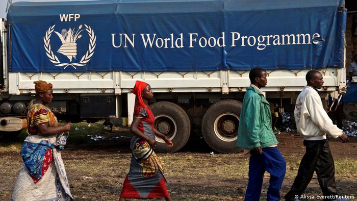 People walking in front of a truck with World Food Programme Banner