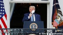 U.S. President Donald Trump takes off his face mask as he comes out on a White House balcony to speak to supporters gathered on the South Lawn for a campaign rally that the White House is calling a peaceful protest in Washington, U.S., October 10, 2020. REUTERS/Tom Brenner