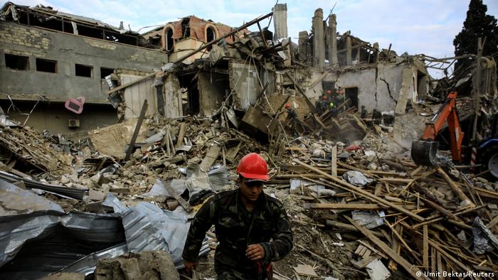A picture of search and rescue teams working on the blast site hit by a rocket during the fighting over the breakaway region of Nagorno-Karabakh in the city of Ganja