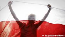 Человек на фоне бело-красно-белого флага - символа белорусской оппозиции